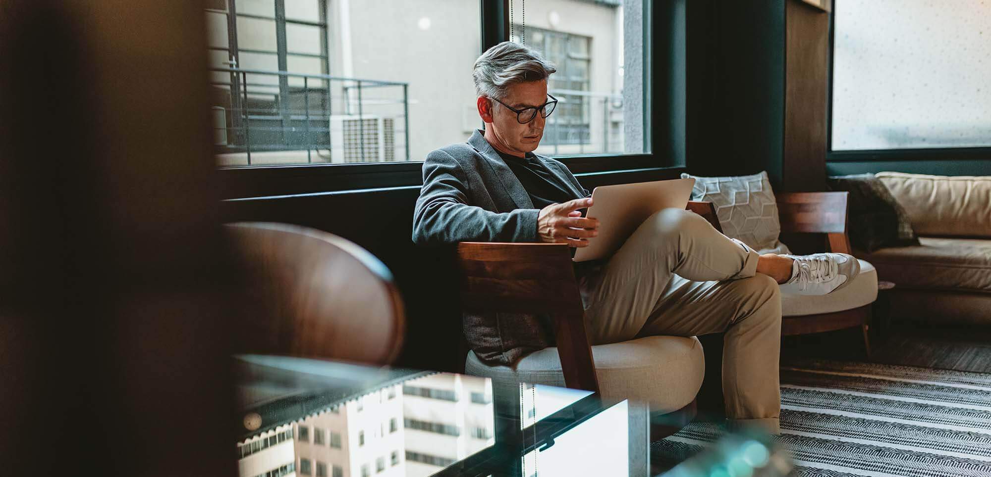 man-sitting-on-chair-using-laptop